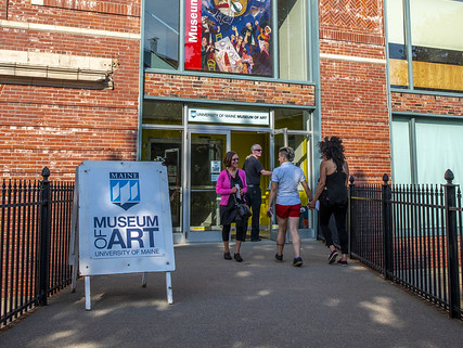 People walking to the door of the Zillman Museum of Art on a sunny afternoon.